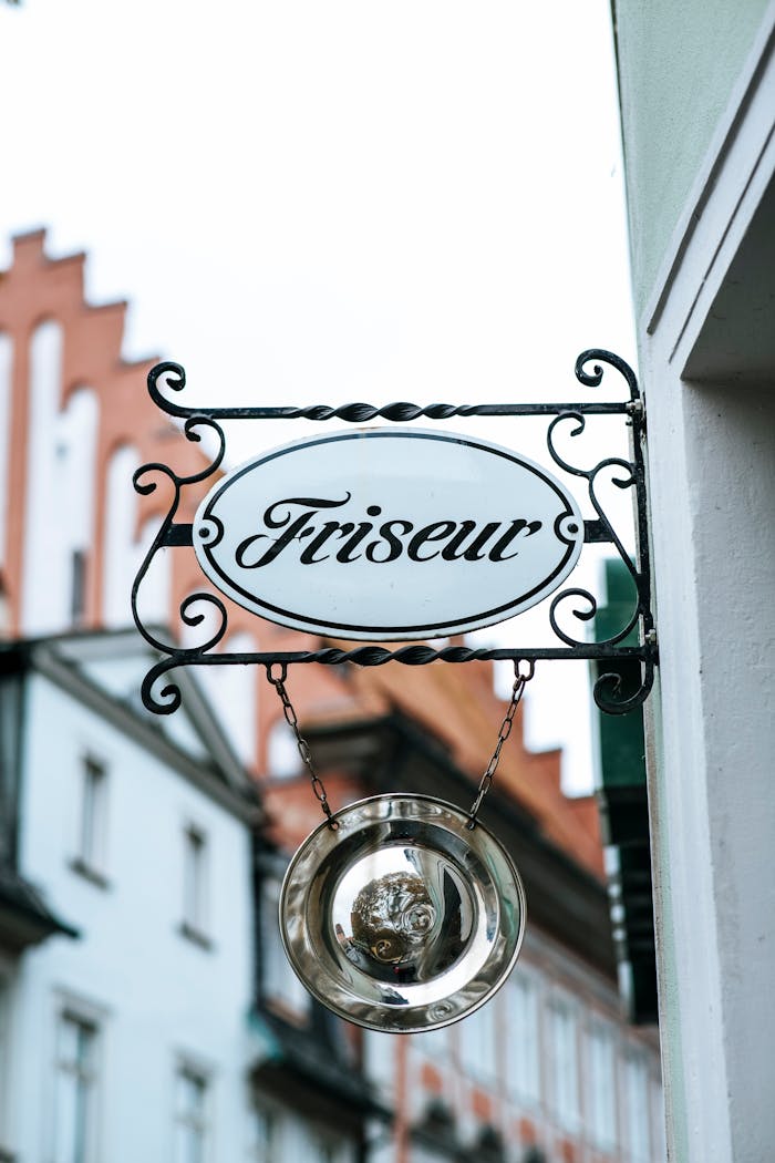 about-01 A vintage-style barber shop sign Friseur in a European urban setting, against historic architecture.