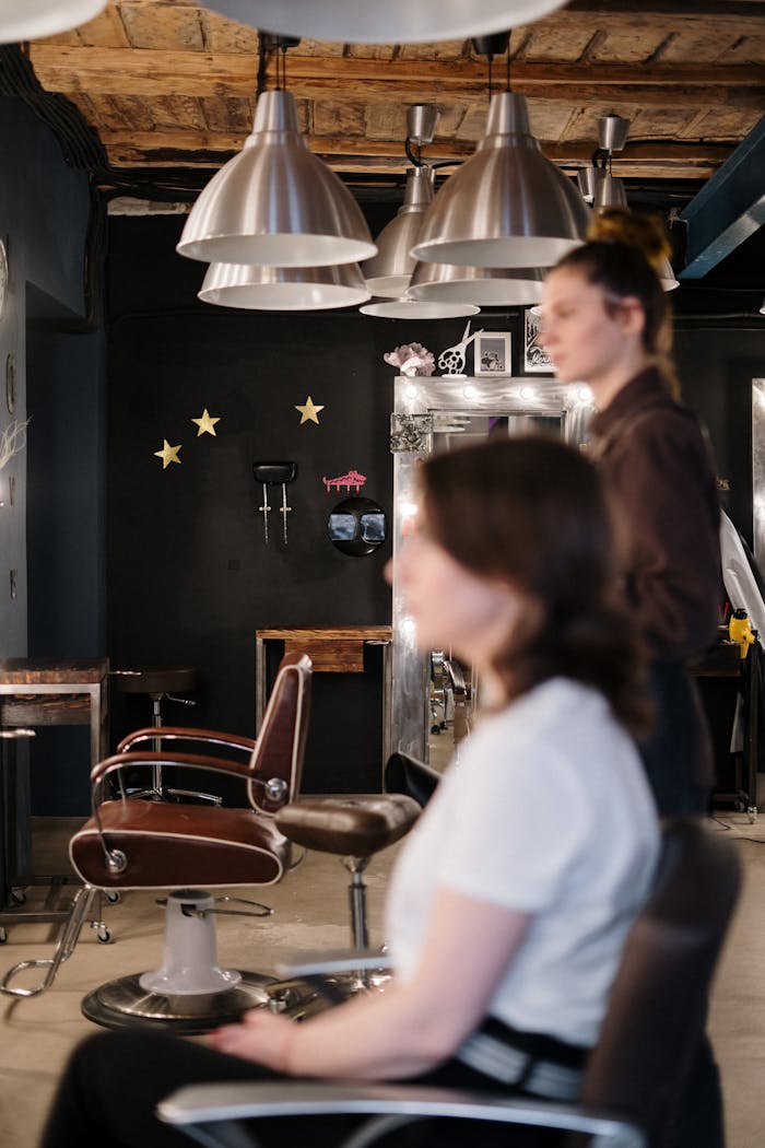 services-02 A hair stylist attends to a client in a modern and stylish salon interior.